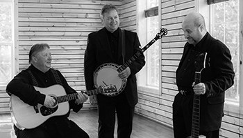 Kruger Brothers talk to each other while holding instruments