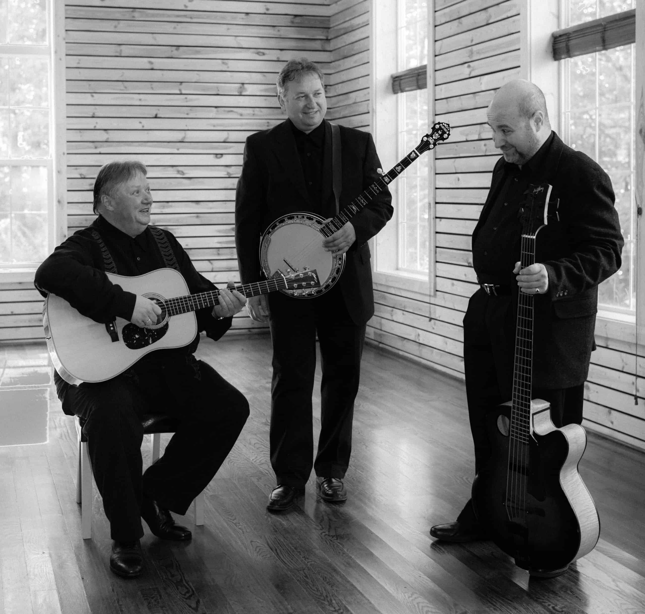 Kruger Brothers talk to each other while holding instruments